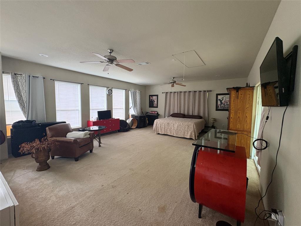 6529 Asher Road Alvarado, TX 76009 - Photo 31 of 39 a living room with furniture a flat screen tv and gym equipment