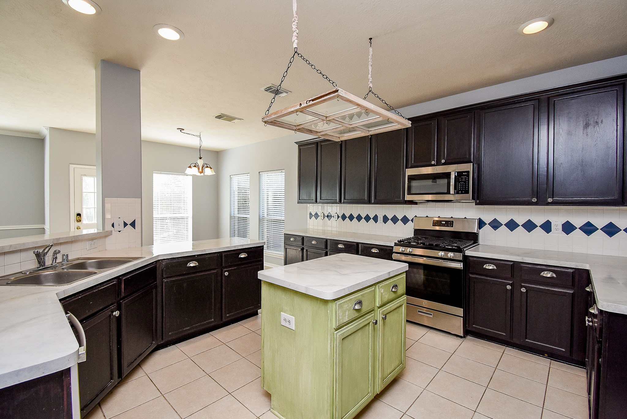 3918 Austin Lake Court Pearland, TX 77581 - Photo 5 of 32 a kitchen with stainless steel appliances granite countertop wooden cabinets a sink a stove a microwave and a refrigerator