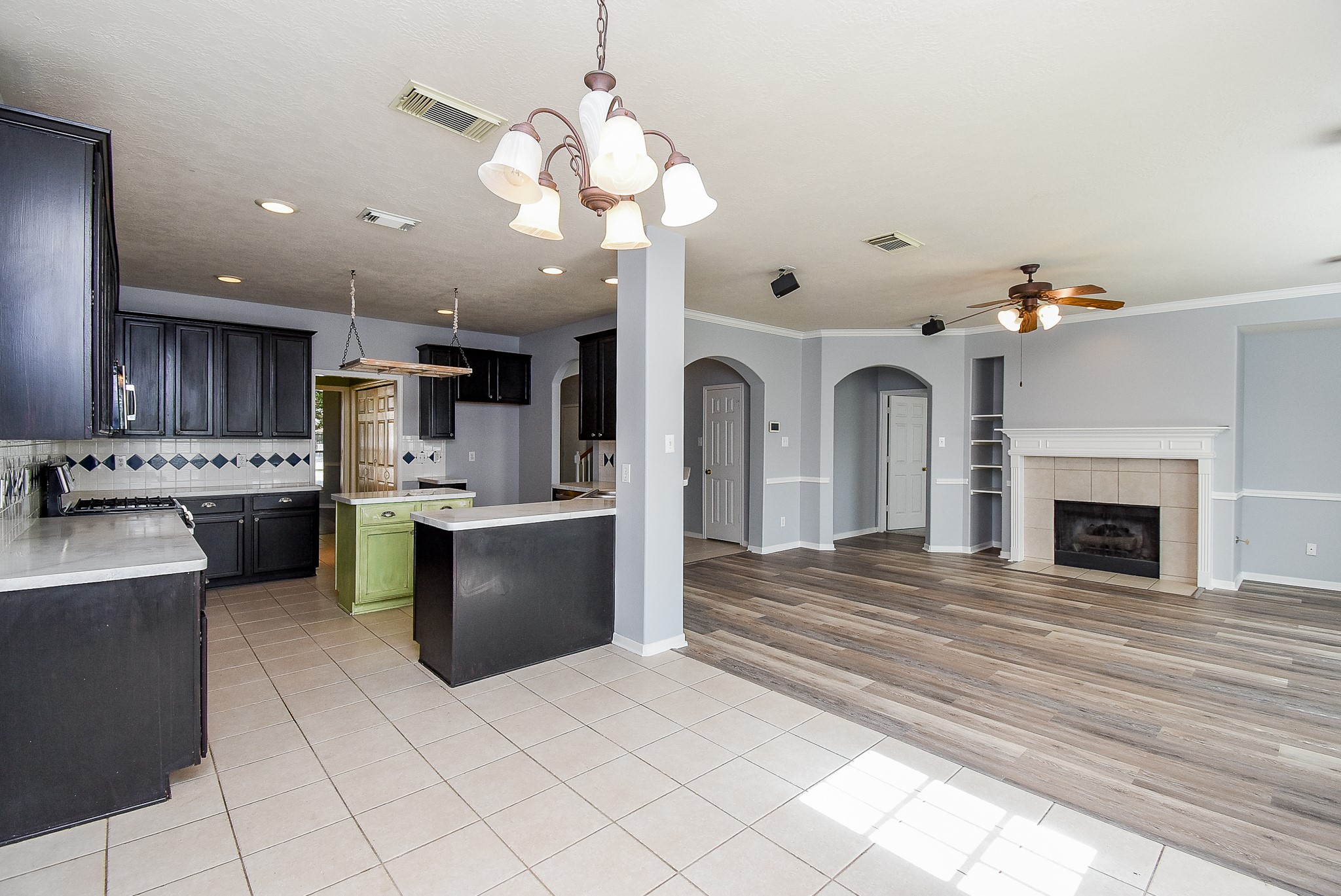 3918 Austin Lake Court Pearland, TX 77581 - Photo 9 of 32 a living room with stainless steel appliances kitchen island a large kitchen island a stove a sink dishwasher and a fireplace with wooden floor