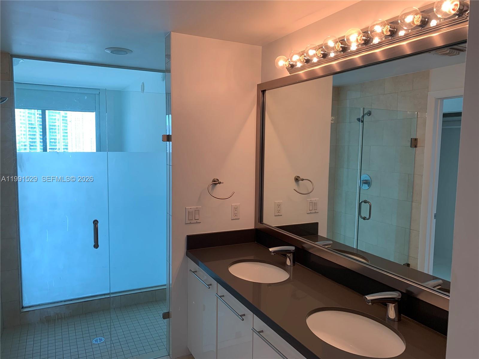 90 Southwest 3rd Street, Unit 3610 Miami, FL 33130 - Photo 14 of 38 a bathroom with a double vanity sink and a mirror