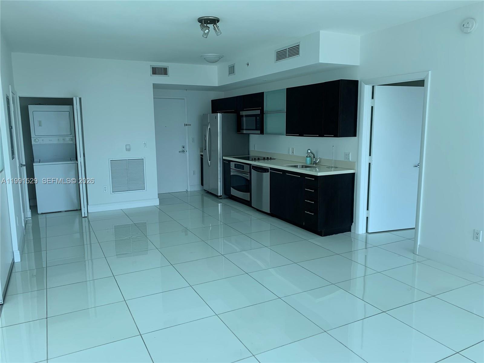90 Southwest 3rd Street, Unit 3610 Miami, FL 33130 - Photo 7 of 38 a kitchen with granite countertop a stove and a microwave