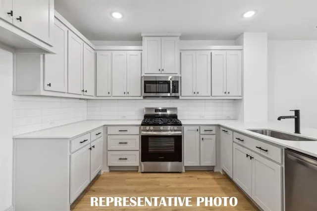 a view of entryway and kitchen with wooden floor