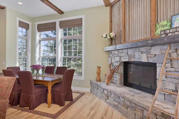 a dining room with furniture a fireplace and wooden floor