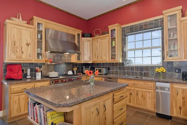 a kitchen with stainless steel appliances granite countertop a sink a stove and cabinets