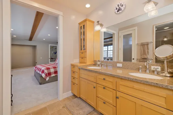 a spacious bathroom with a granite countertop sink a toilet a mirror and bathtub