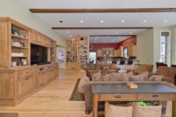 a large kitchen with stainless steel appliances kitchen island granite countertop a sink and a view of living room