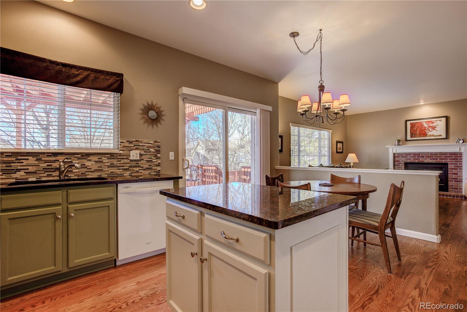 873 Riddlewood Lane Highlands Ranch, CO 80129 - Photo 8 of 35 a kitchen with granite countertop white cabinets and chandelier