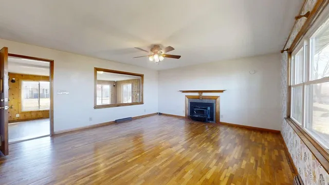 an empty room with windows and fireplace