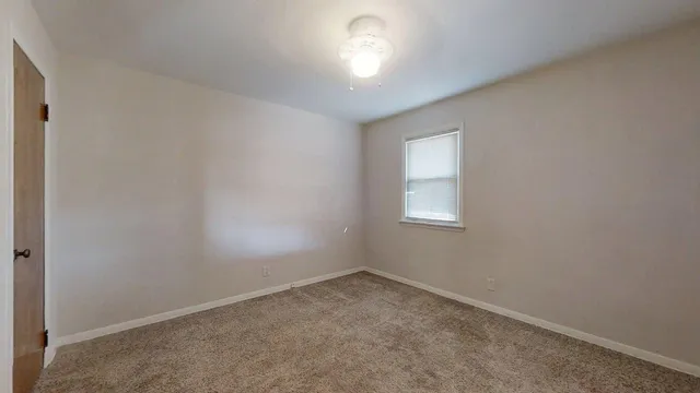 an empty room with a window and closet