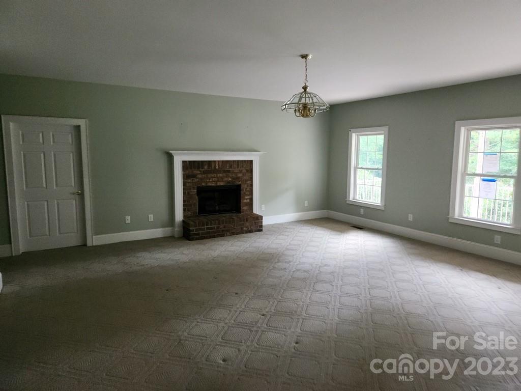 360 Hooper Creek Road Tryon, NC 28782 - Photo 16 of 38 an empty room with windows and fireplace