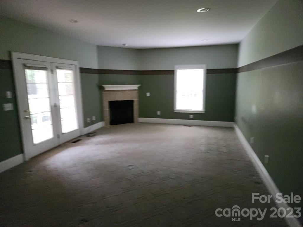 360 Hooper Creek Road Tryon, NC 28782 - Photo 23 of 38 an empty room with a fireplace and window