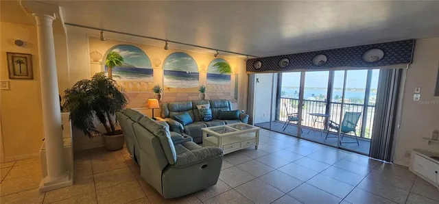 a dining area with stainless steel appliances kitchen island granite countertop a table chairs and chandelier