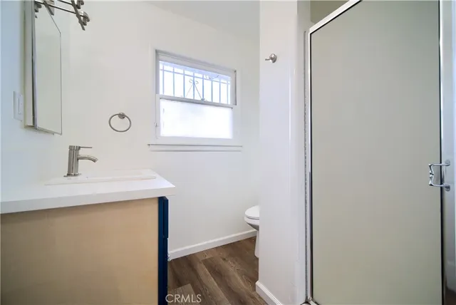 a bathroom with a sink a toilet and a window