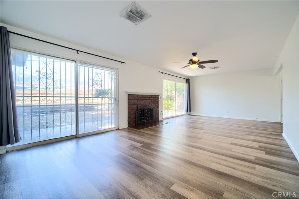 6083 Merito Avenue San Bernardino, CA 92404 - Photo 3 of 17 wooden floor in an empty room with a fireplace