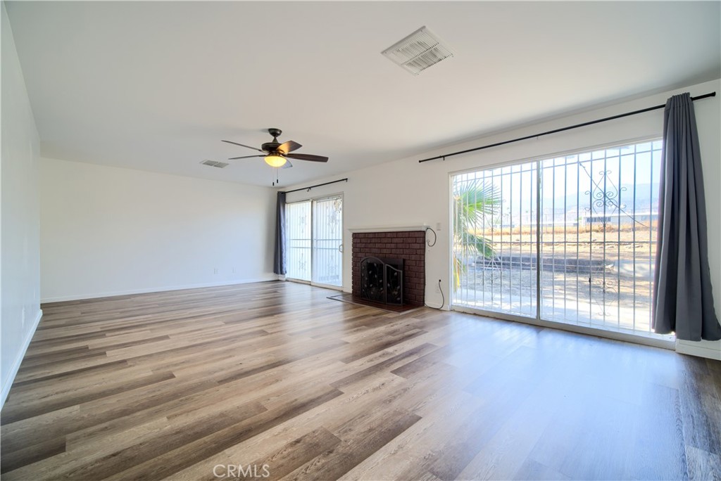6083 Merito Avenue San Bernardino, CA 92404 - Photo 4 of 17 wooden floor in an empty room with a fireplace