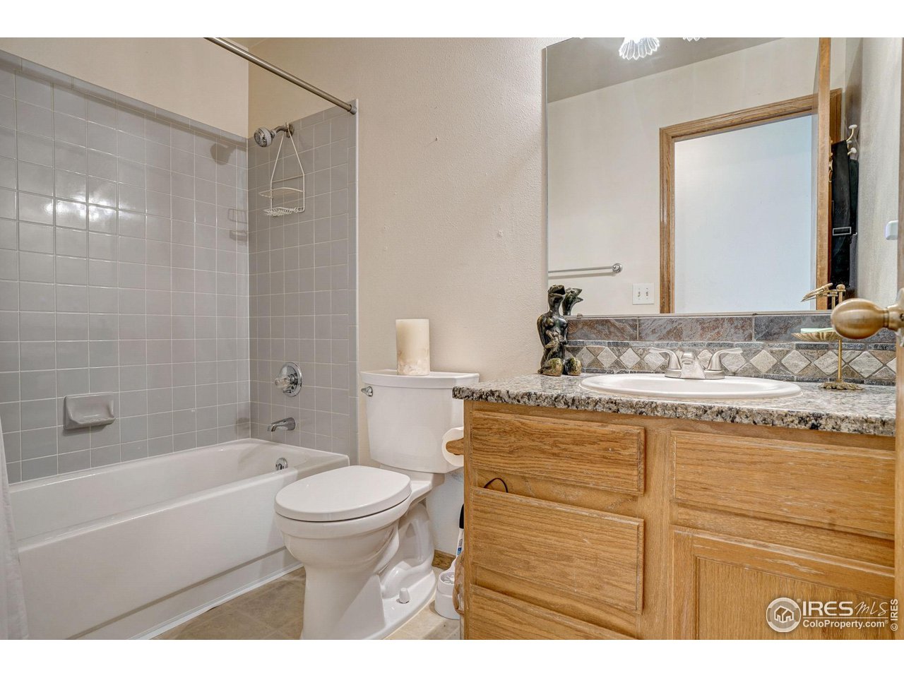 3317 Laredo Lane Fort Collins, CO 80526 - Photo 14 of 33 a bathroom with a granite countertop sink a toilet and a bathtub