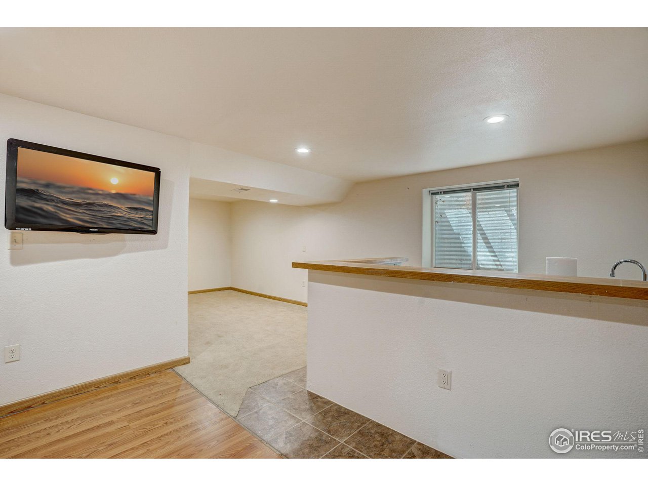 3317 Laredo Lane Fort Collins, CO 80526 - Photo 25 of 33 a view of an empty room with wooden floor and a flat screen tv