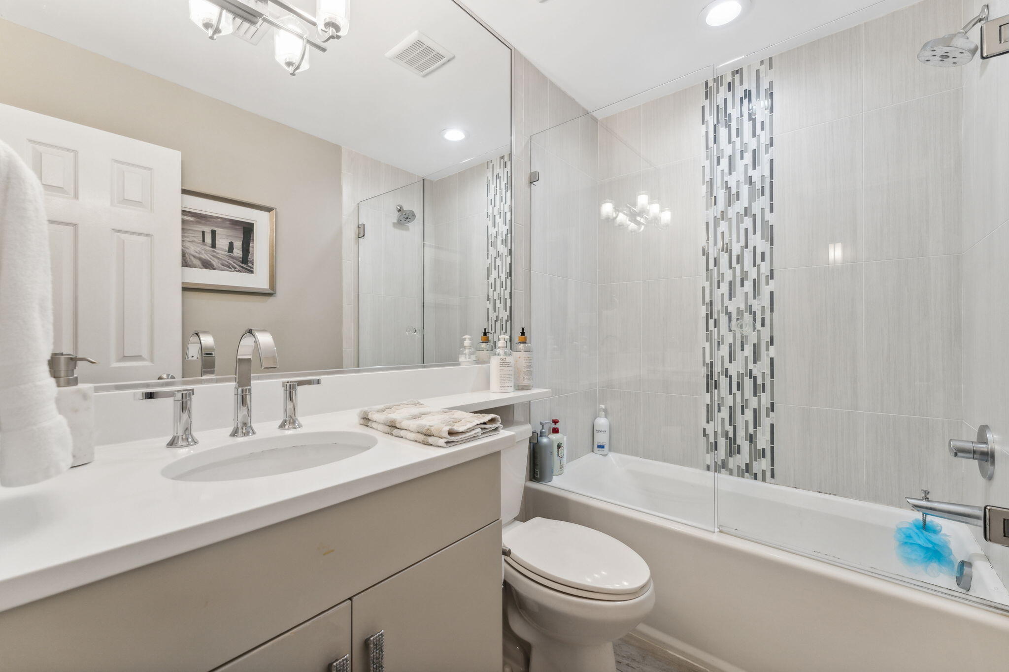 23011 Front Beach Road, Unit E47 Panama City Beach, FL 32413 - Photo 25 of 29 a bathroom with a sink a toilet a mirror a vanity a bathtub and shower