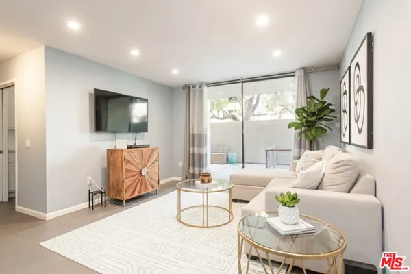 a living room with furniture flat screen tv and a large window