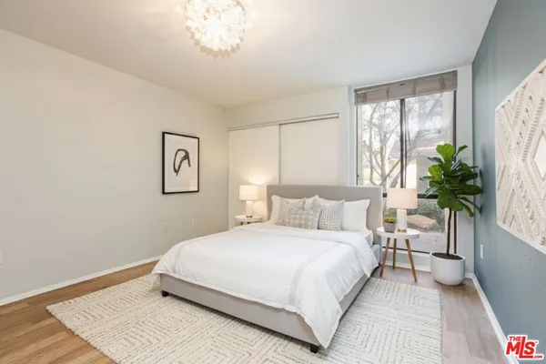a bedroom with a large bed and a chandelier