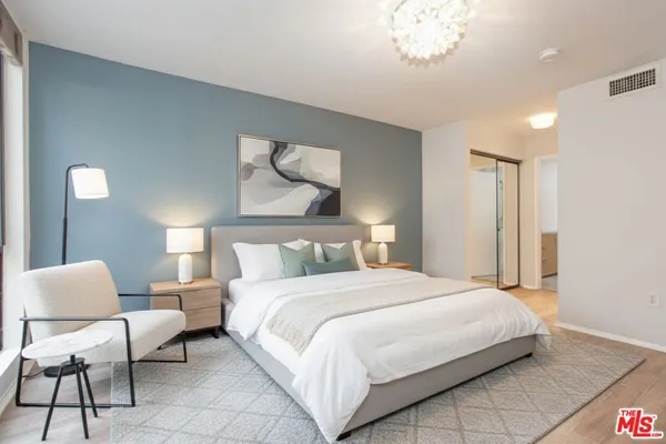 a bedroom with a bed and a chandelier