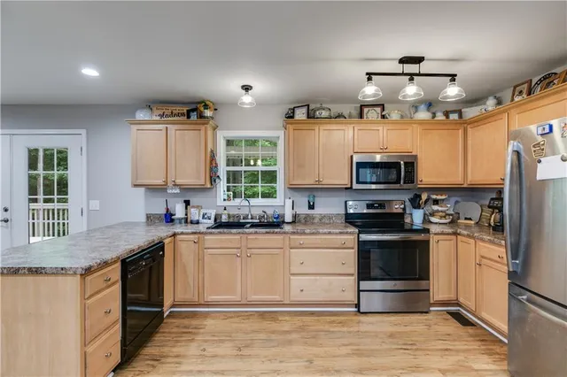a kitchen with stainless steel appliances granite countertop a sink stove and refrigerator