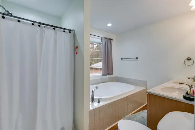 a bathroom with a granite countertop sink toilet and shower