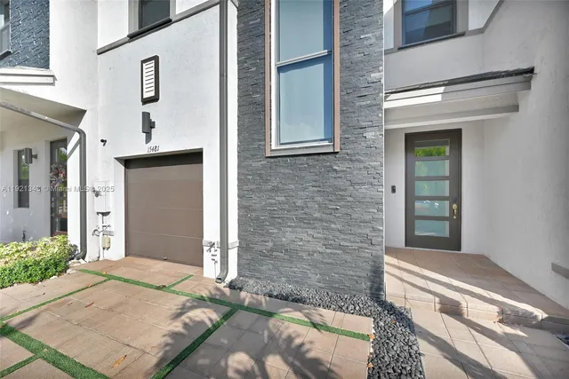 a view of a house with a yard and a large tree