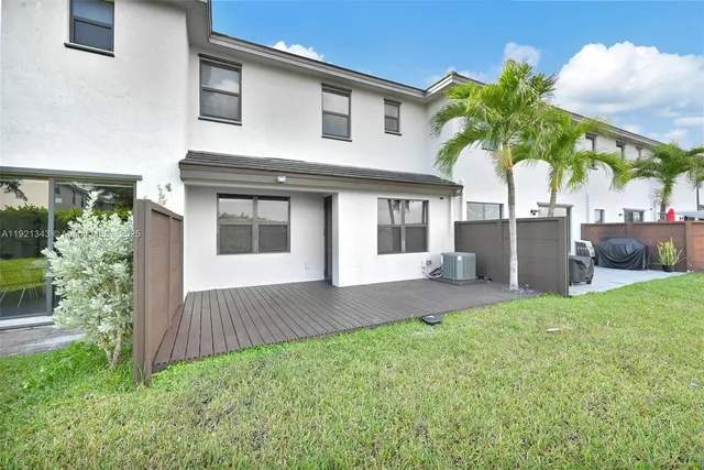 a view of a terrace hall with wooden floor and a yard