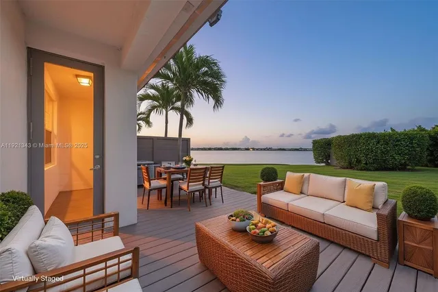 an outdoor living room with furniture and a large window