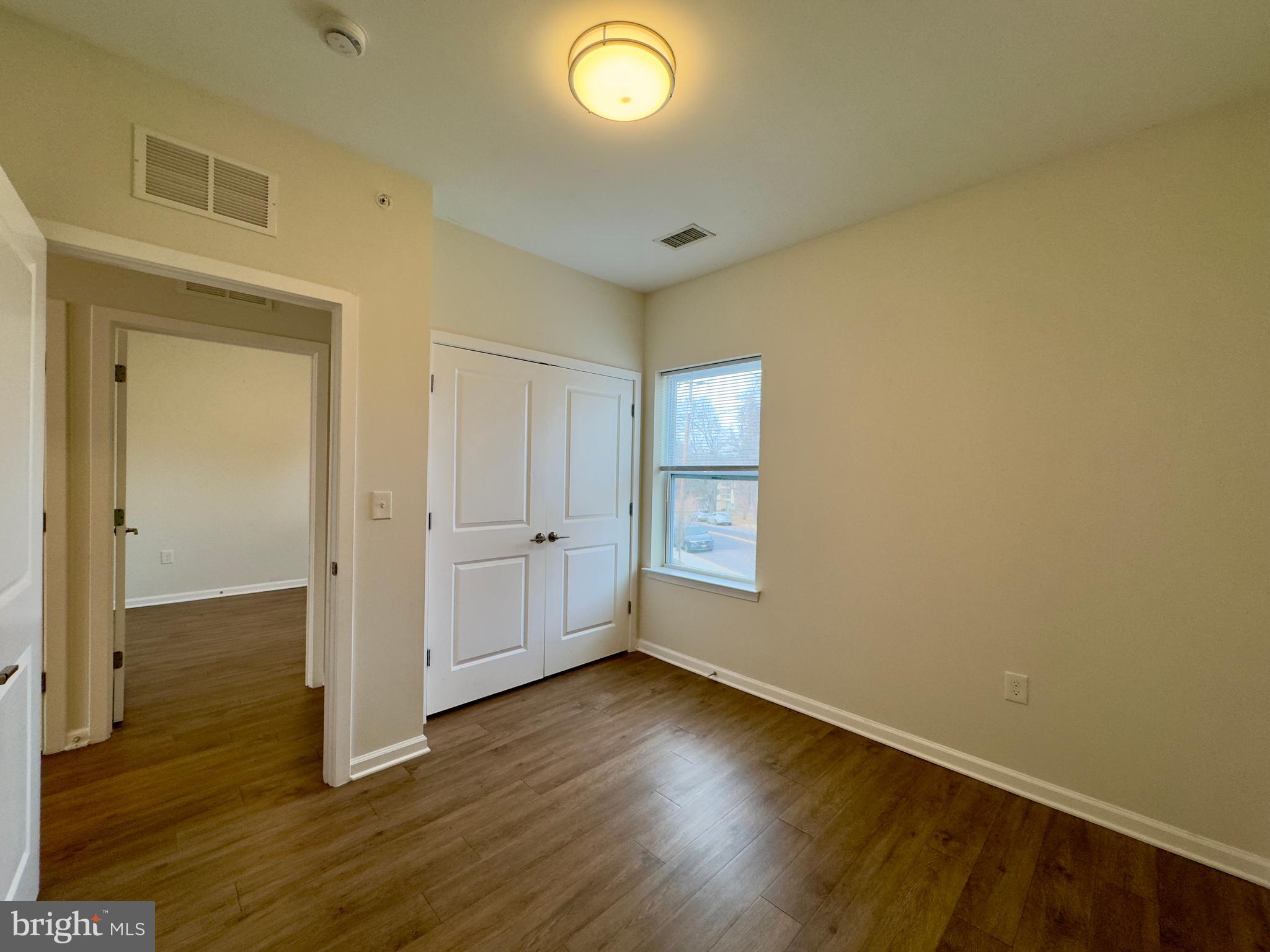 4909 Hamilton Avenue, Unit 4909B Baltimore, MD 21206 - Photo 14 of 15 an empty room with wooden floor and windows