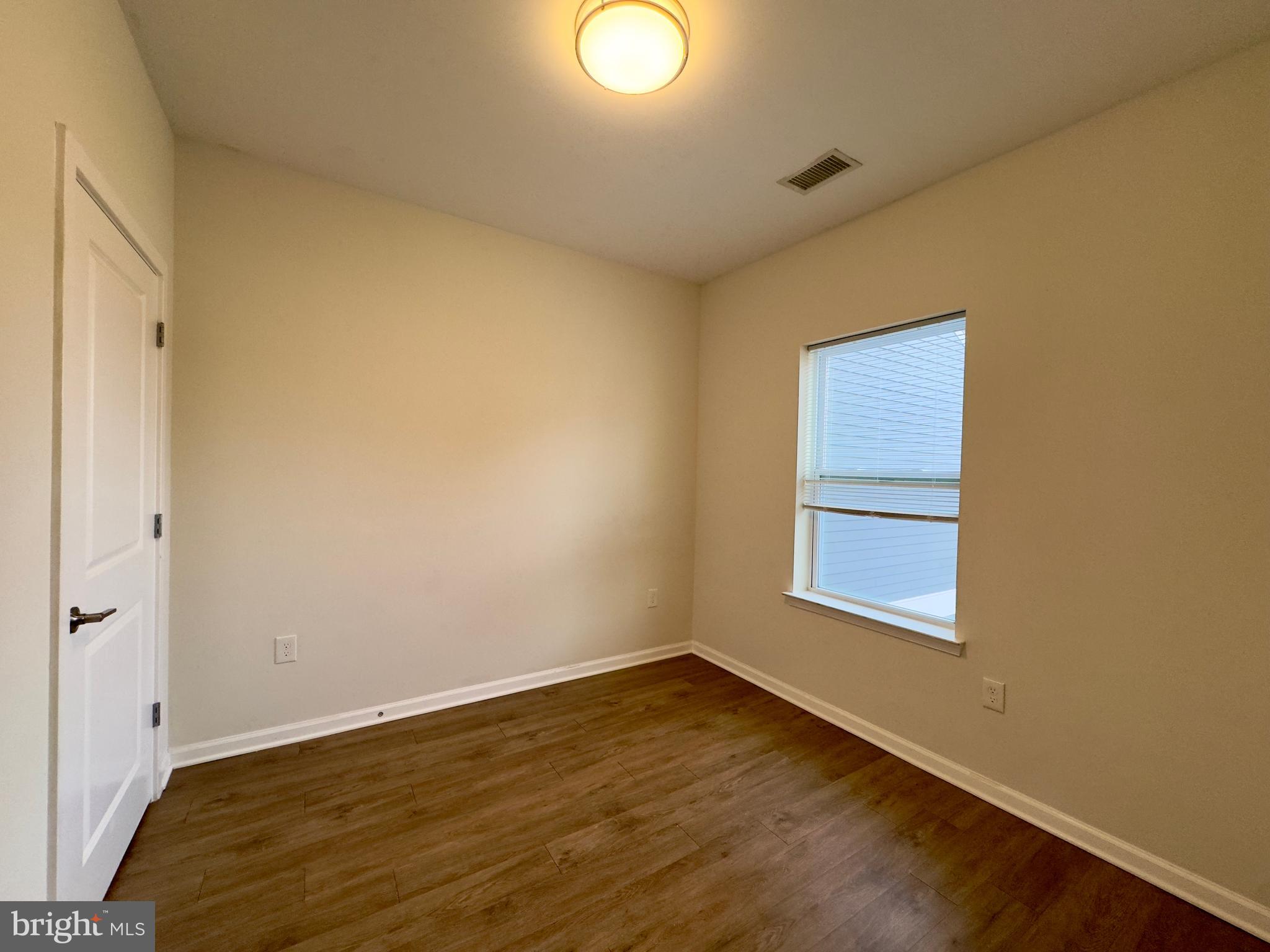 4909 Hamilton Avenue, Unit 4909B Baltimore, MD 21206 - Photo 15 of 15 an empty room with wooden floor and windows