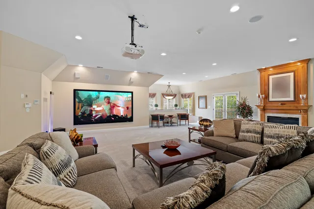 a large white kitchen with kitchen island granite countertop lots of white stainless steel appliances a stove a sink a counter top space and living room view