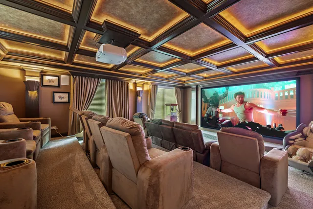a media room with lots of chairs and a chandelier