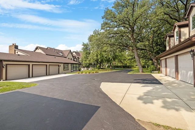 a view of a house with a big yard and large trees