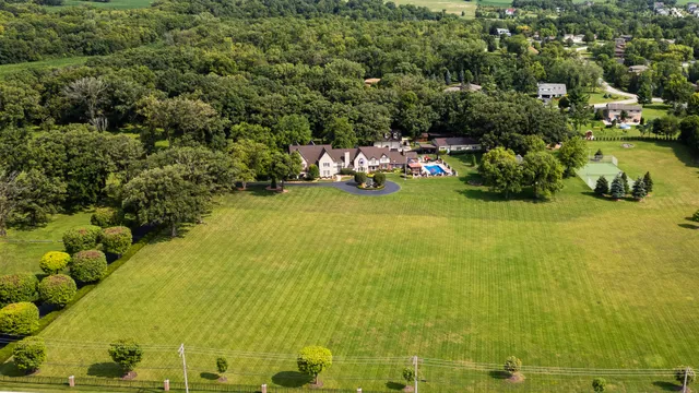 a front view of a house with a garden and trees