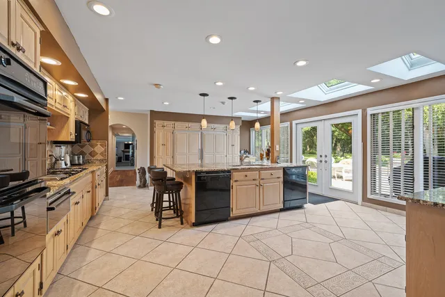 a large kitchen with a large counter top space and stainless steel appliances
