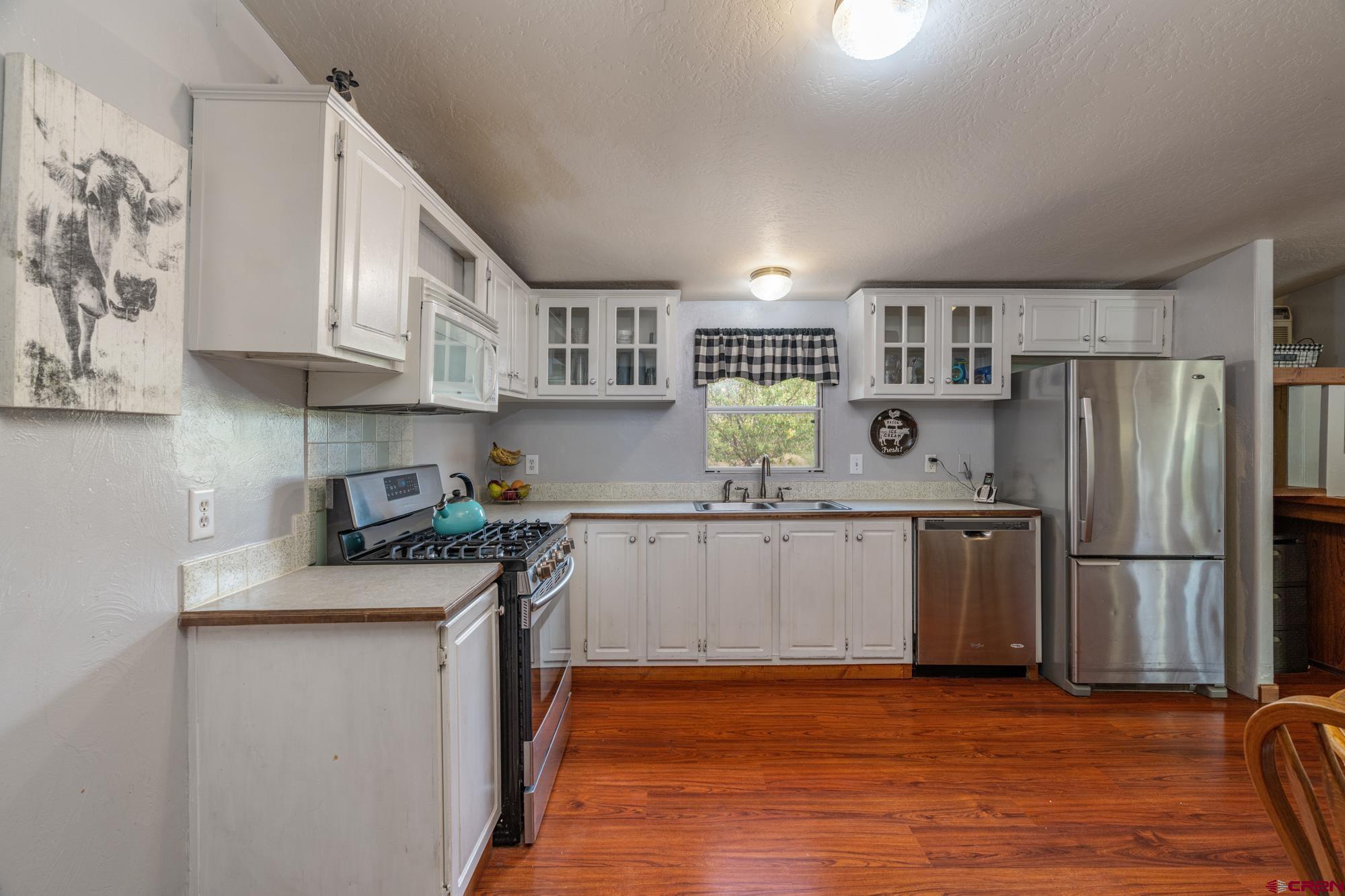 25109 Rd L.4 Cortez, CO 81321 - Photo 12 of 33 a kitchen with stainless steel appliances granite countertop a refrigerator a stove top oven a sink and dishwasher