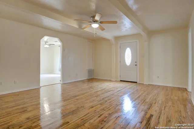 an empty room with wooden floor and mirror