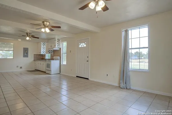a view of a livingroom with a chandelier fan and windows