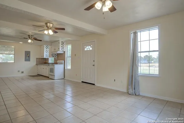 a view of a livingroom with a chandelier fan and windows