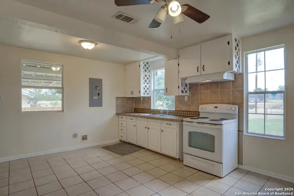 a kitchen with cabinets appliances and a window