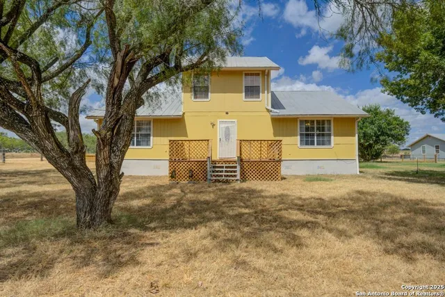 front view of a house with a large tree