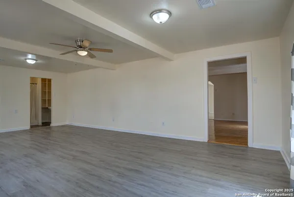 an empty room with wooden floor chandelier fan and closet in a room