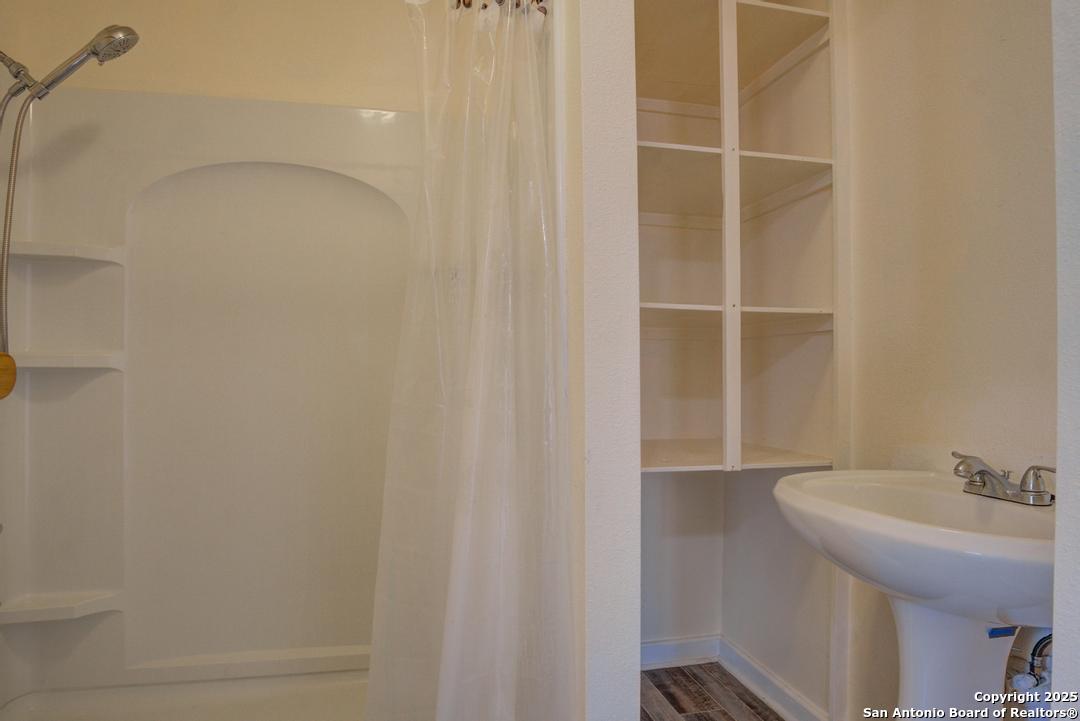 1176 Old Adams Lane Pleasanton, TX 78064 - Photo 8 of 42 a bathroom with a sink and a shower