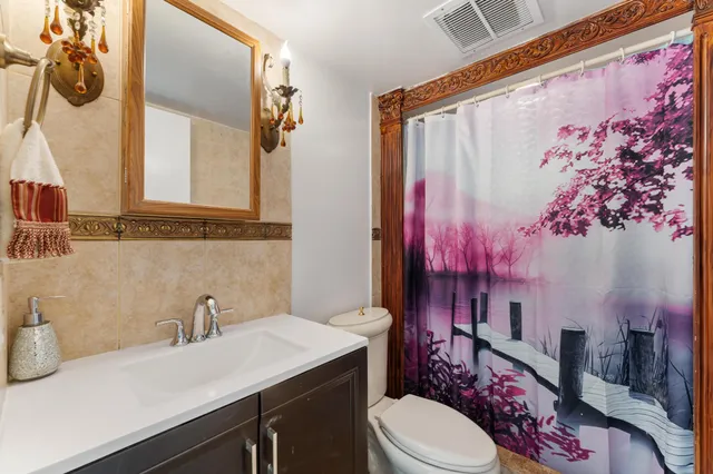 a bathroom with a sink vanity mirror and toilet