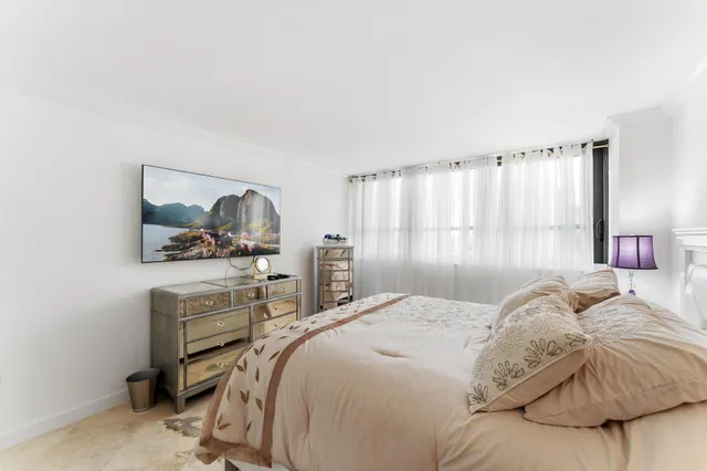 a bedroom with a bed window and a television
