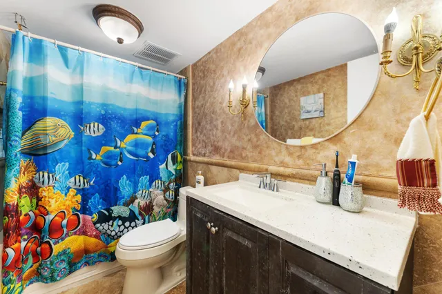 a bathroom with a sink mirror vanity and toilet