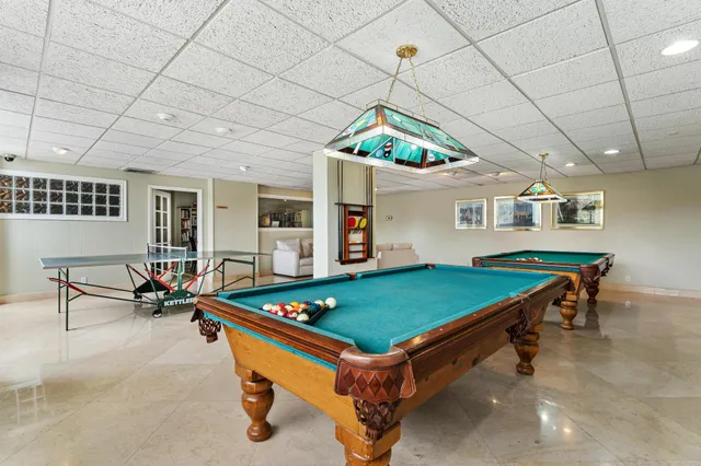 a living room with furniture a piano and a bookshelf