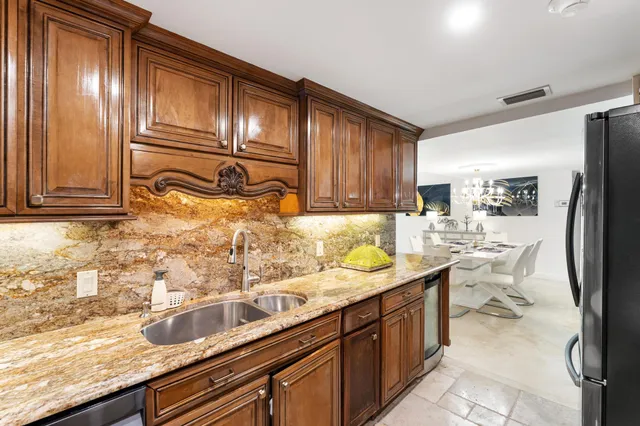 a kitchen with a sink refrigerator and cabinets